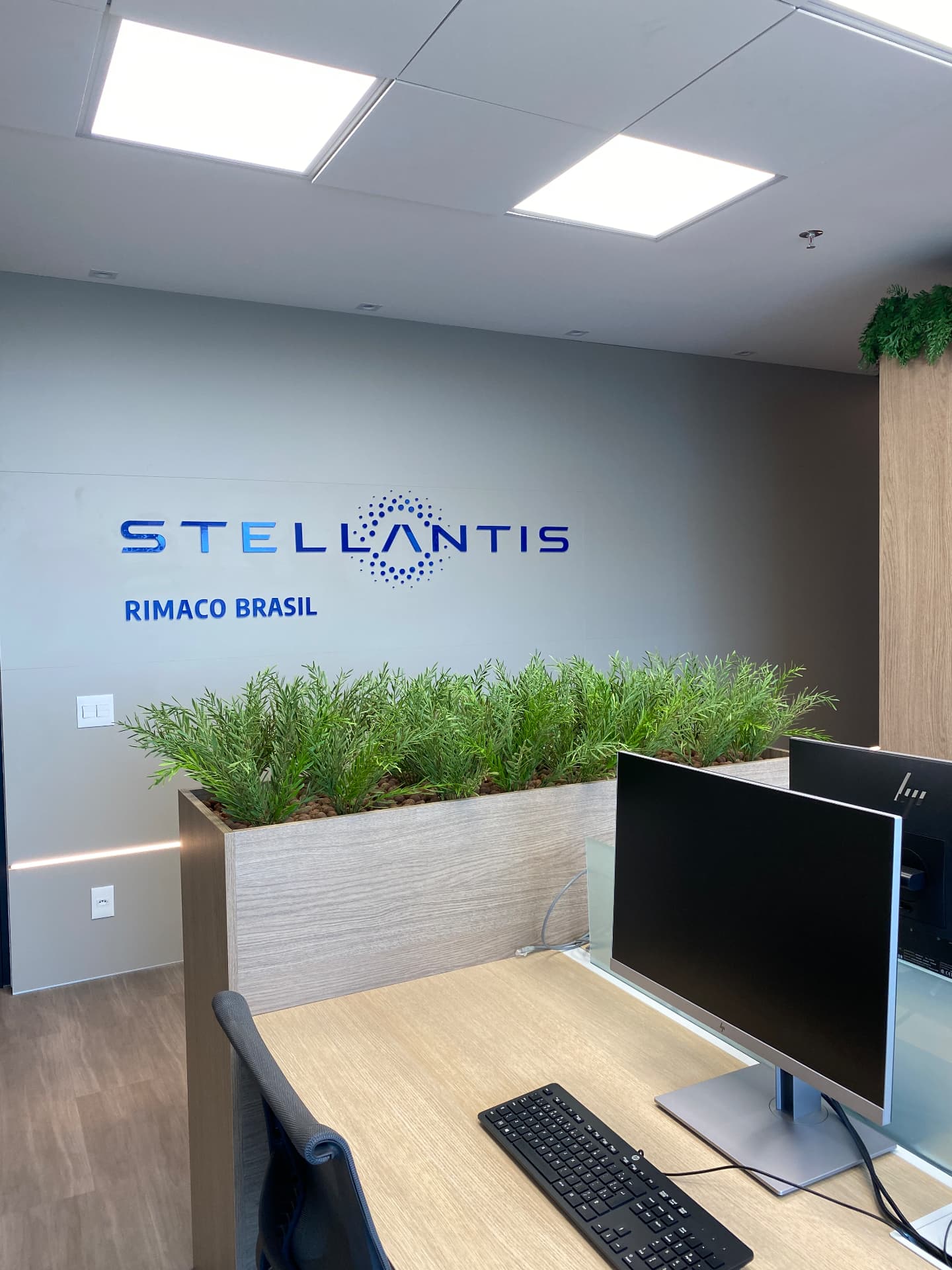 Jardineira de folhagens sob o letreiro Stellantis Rimaco Brasil na recepção da sede
