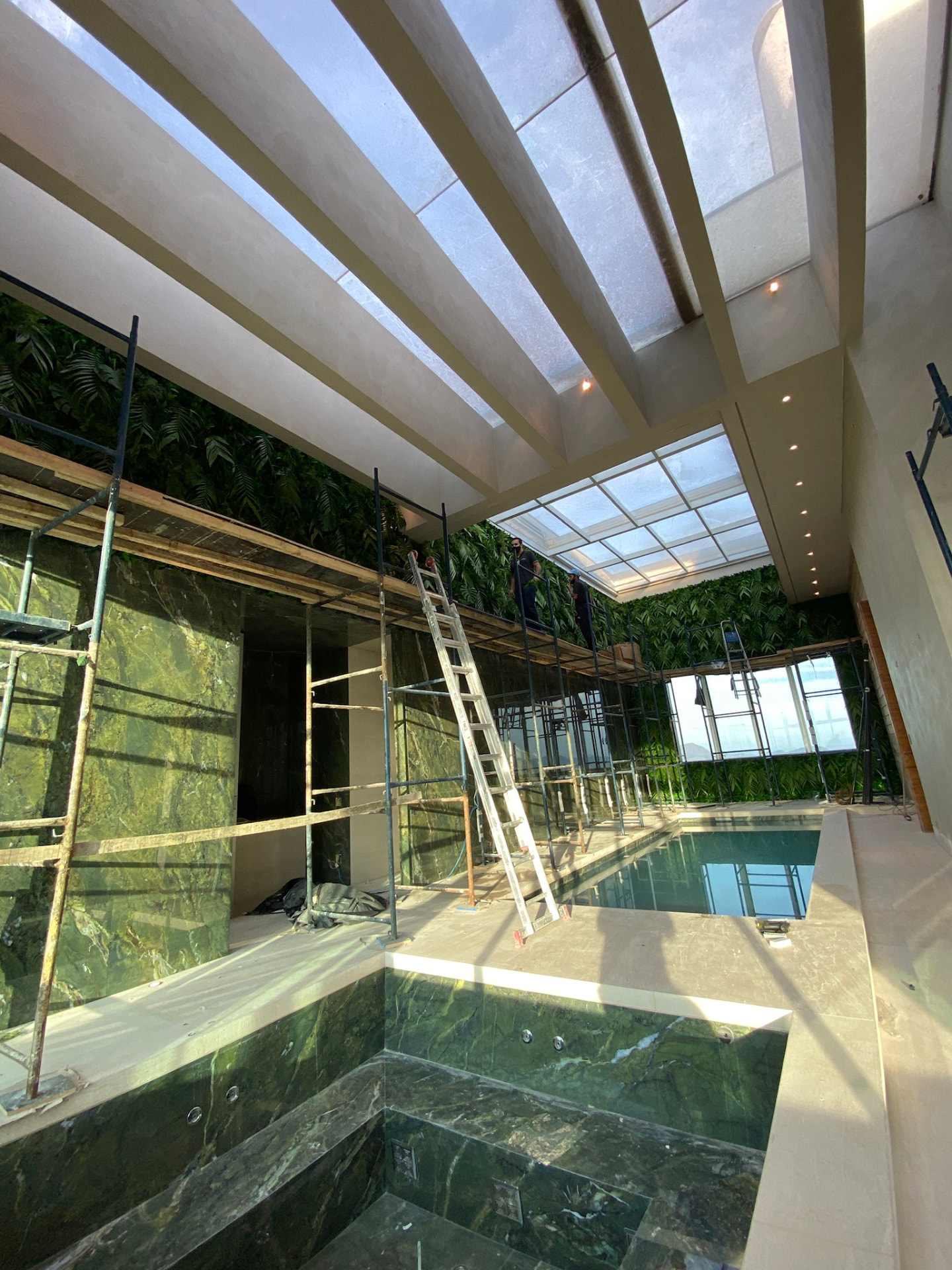Obra da Cobertura LFP com spa em mármore verde e parede verde em montagem