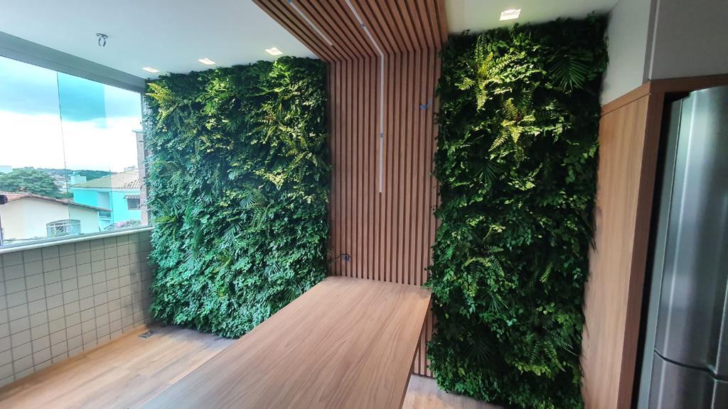 Dois painéis de jardim vertical preservado em varanda gourmet com marcenaria ripada