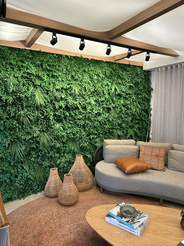 Jardim vertical preservado em sala de estar com iluminação de trilho e sofá