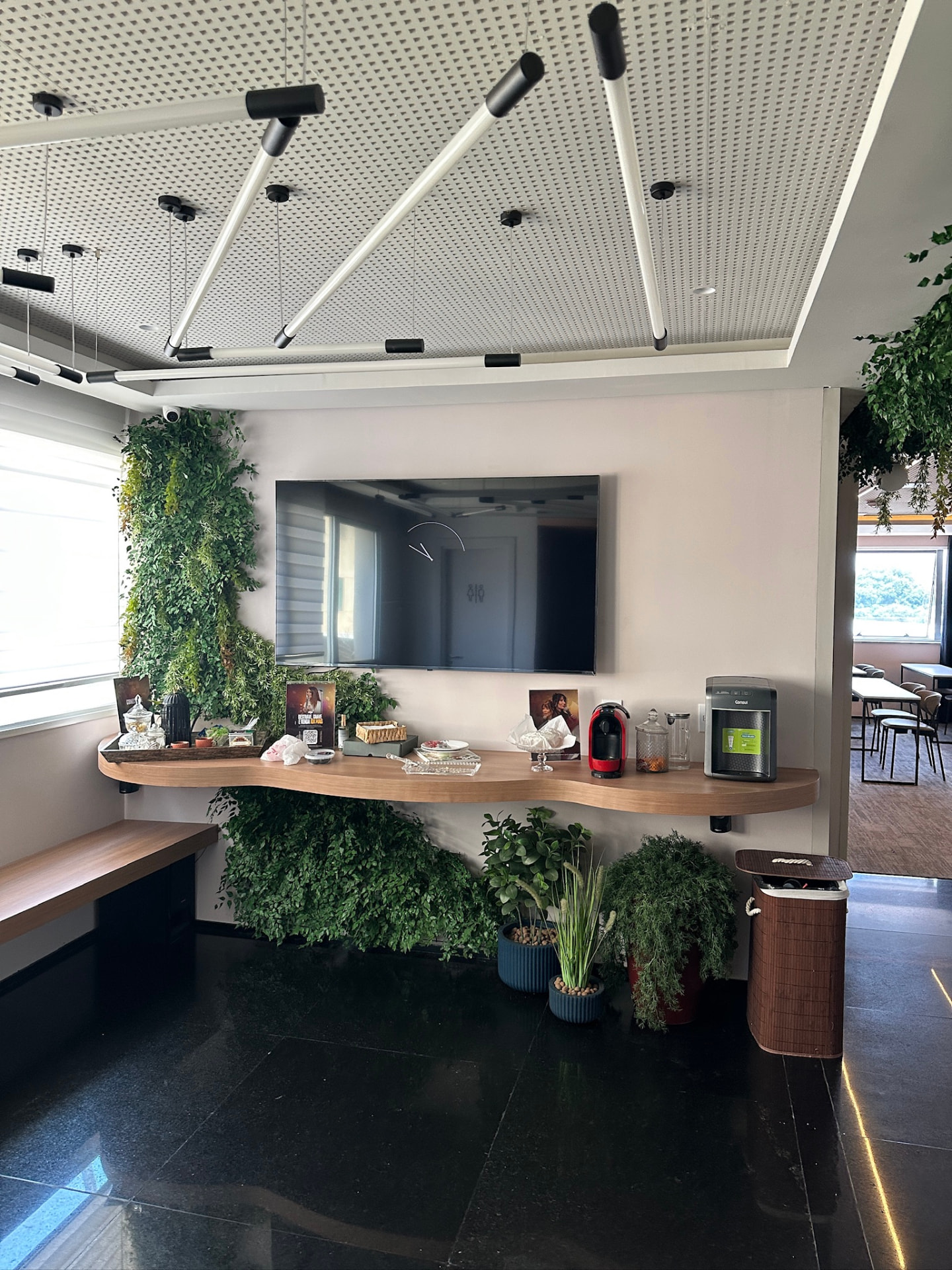 Painel de jardim vertical preservado integrado à televisão e à bancada de convivência da ML2 Company