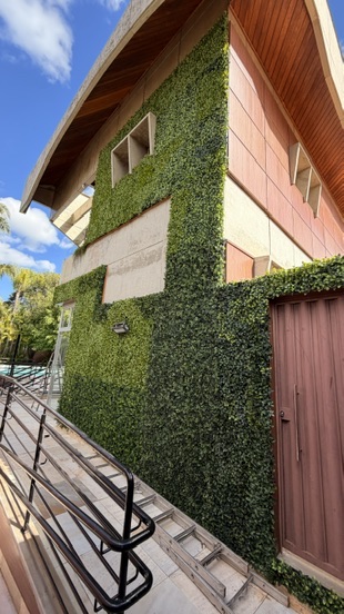 Fachada lateral da JMM Tech totalmente revestida em parede verde permanente com proteção UV