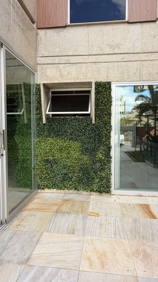 Detalhe do recorte da parede verde permanente em torno de janela basculante na fachada da JMM Tech