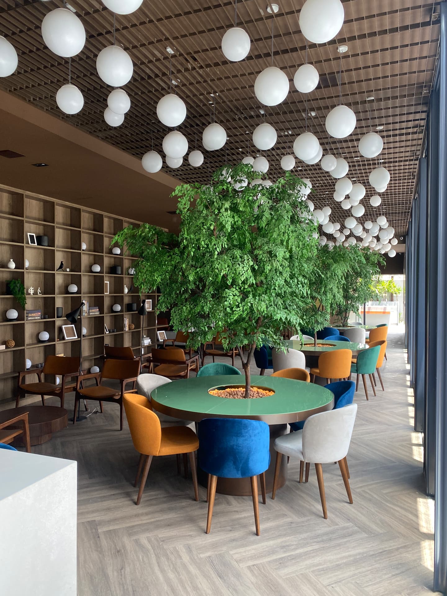 Café · salão integrado com árvores nas mesas