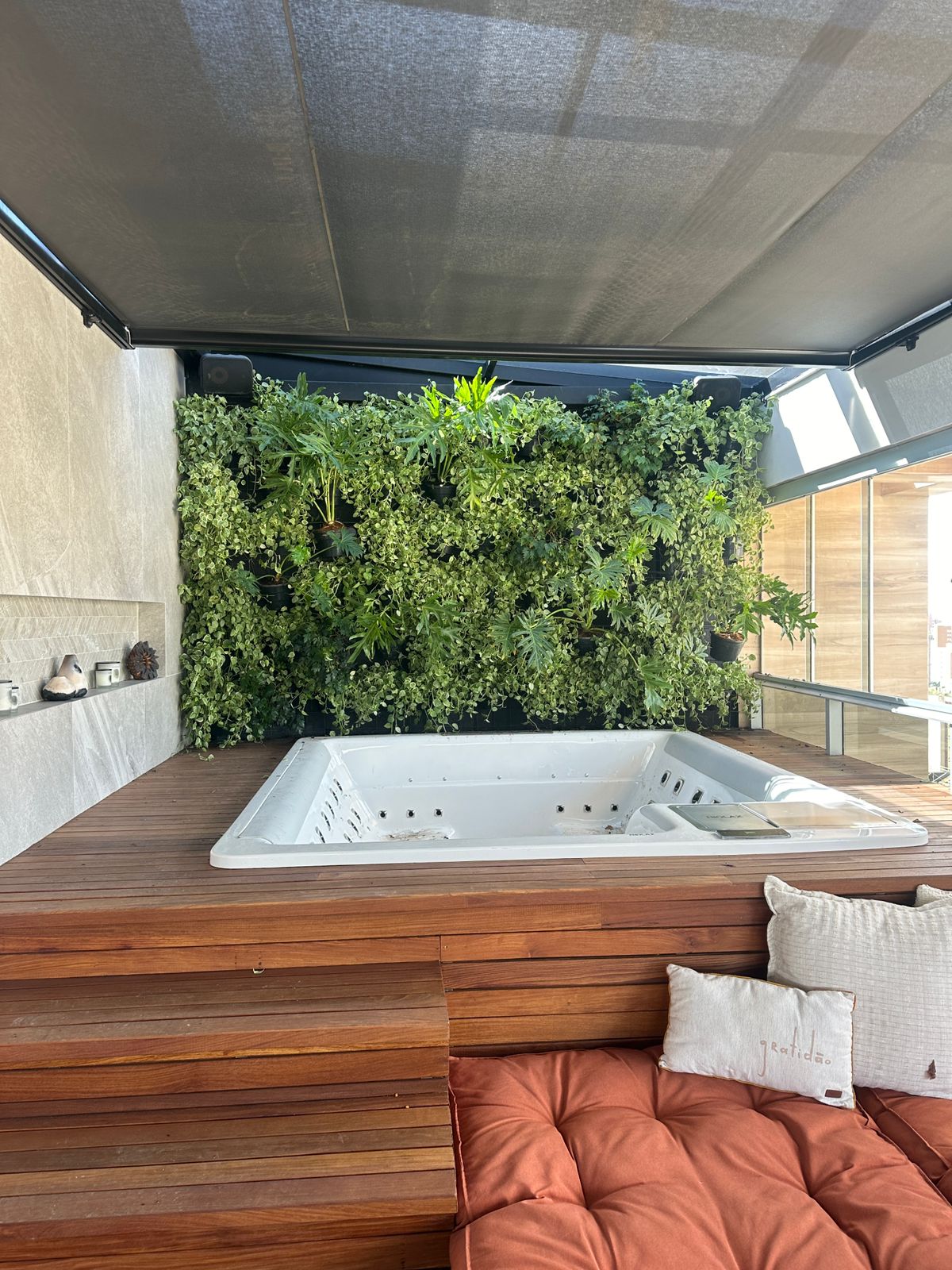 Painel de jardim natural em deck de madeira com plantas pendentes podadas pela equipe fixa
