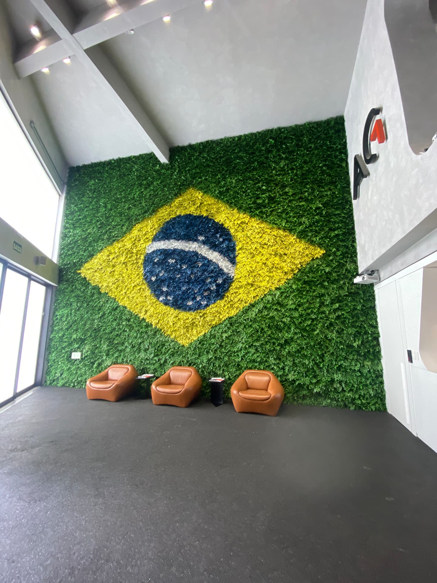 Bandeira do Brasil em plantas preservadas vista de perto na recepção da Avantgarde Motors