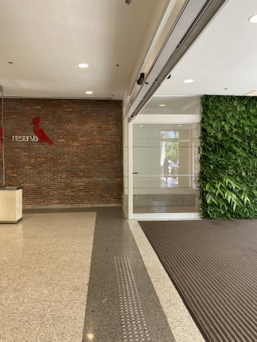 Circulação da entrada do BH Shopping com piso granilite e painel de plantas preservadas à direita