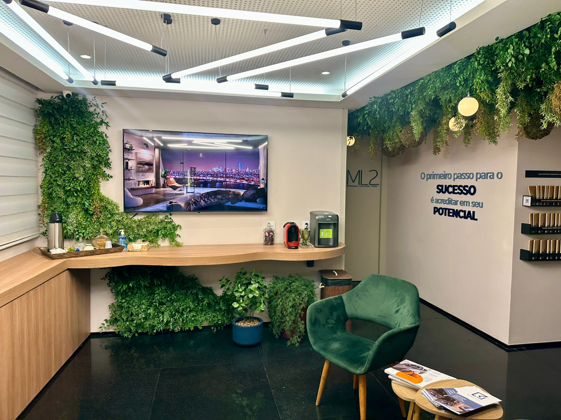 Recepção da ML2 Company com painel vertical preservado, bancada de café e teto verde com esferas de musgo