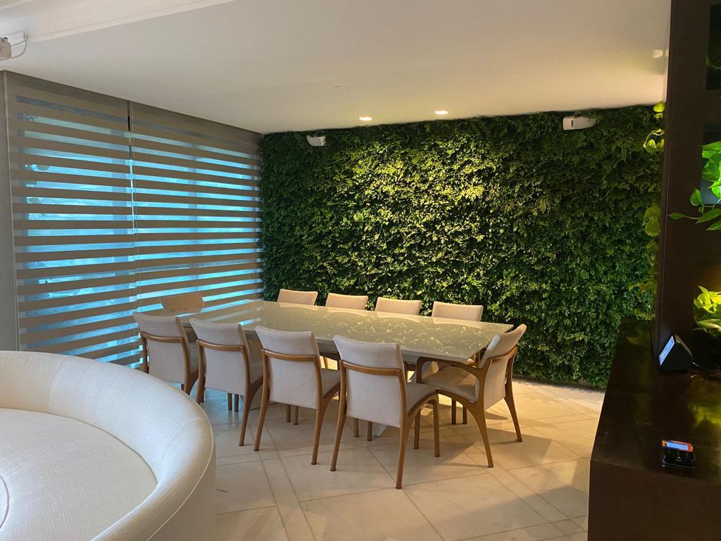 Jardim vertical preservado em sala de reunião com mesa para dez lugares