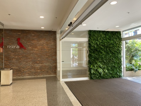 Vista ampla da entrada do BH Shopping com painel de plantas preservadas em toda a altura do vão