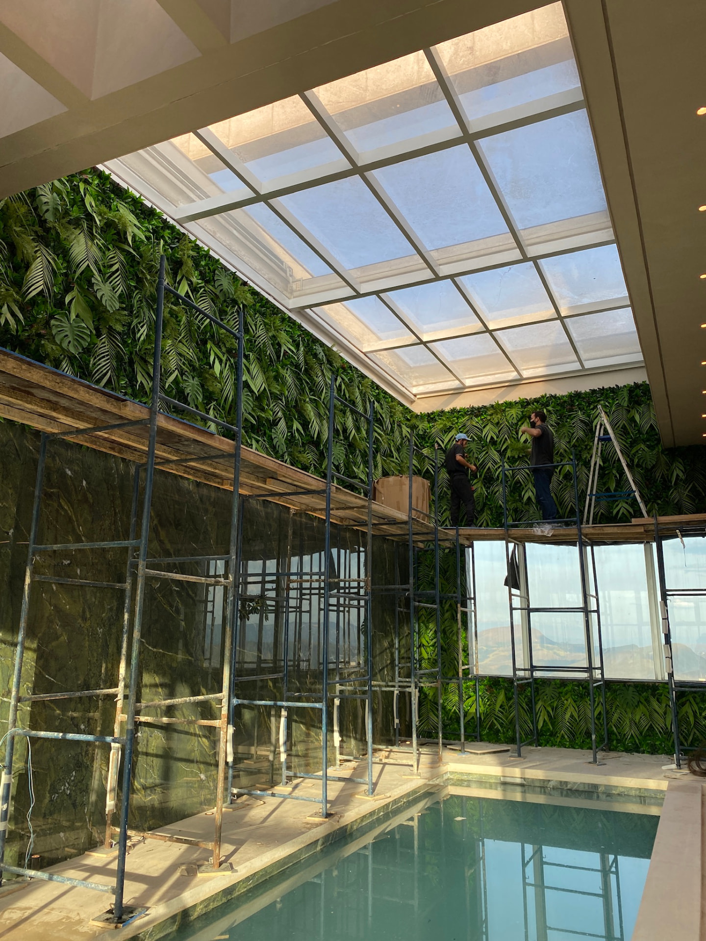 Montagem da parede verde da Cobertura LFP com andaimes ao longo da piscina