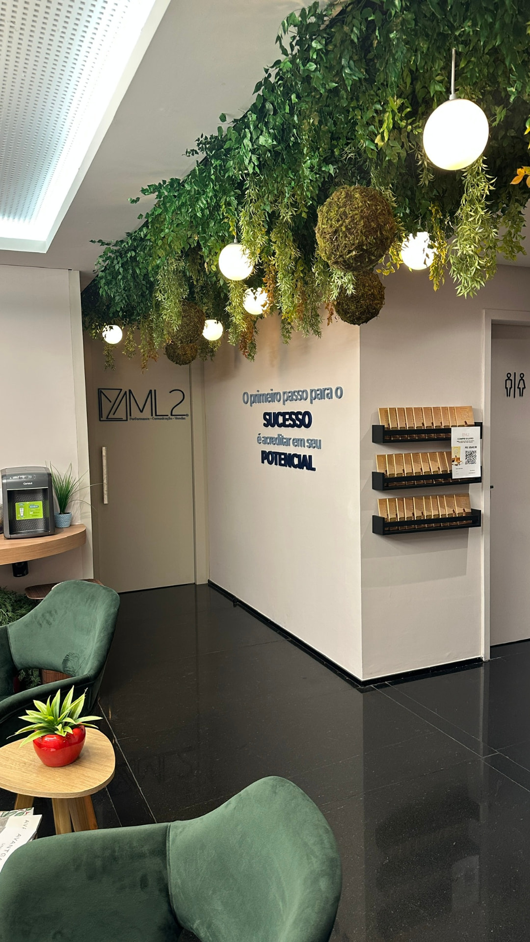 Entrada da ML2 Company com logotipo, teto verde preservado e expositores
