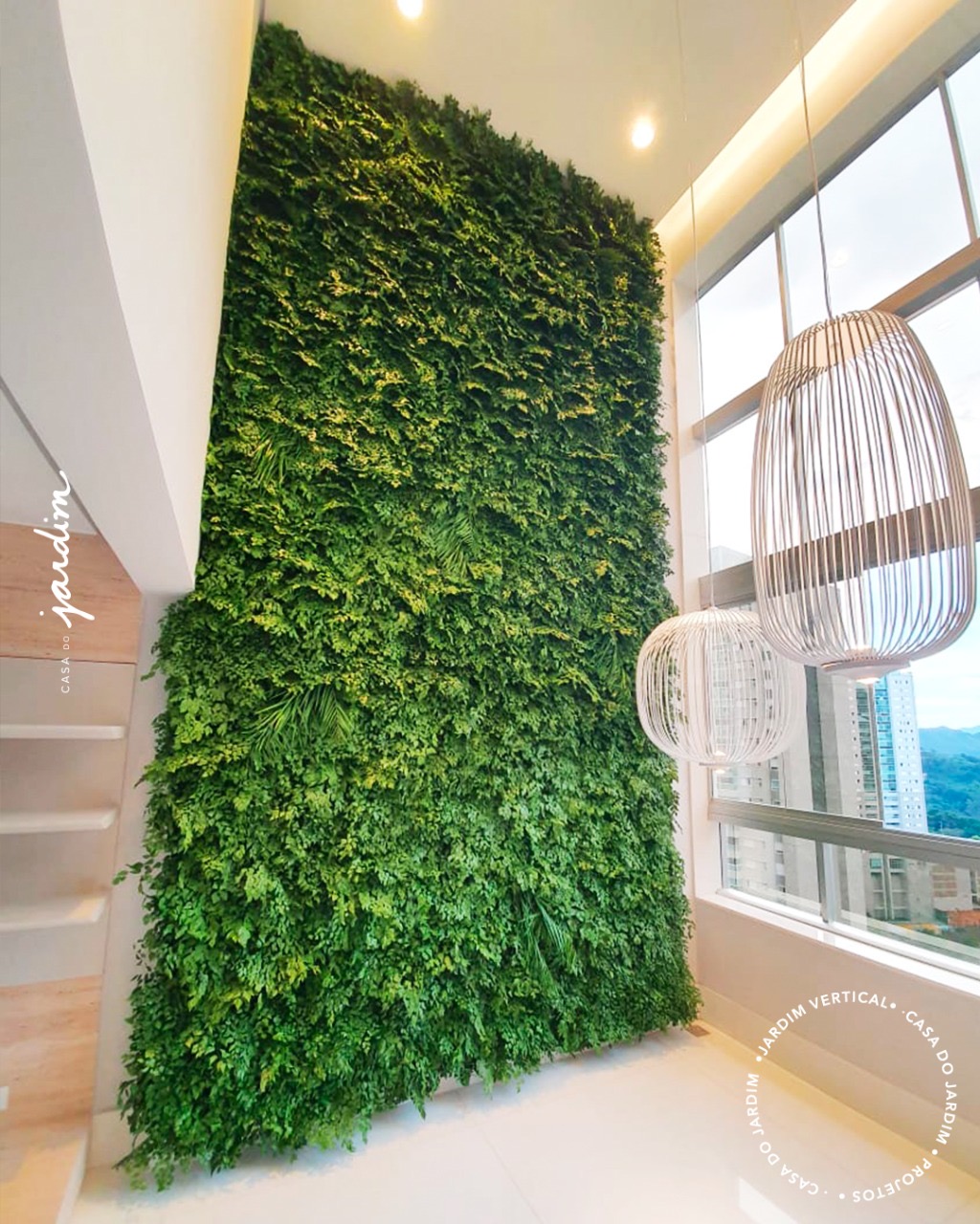 Jardim vertical preservado de pé-direito duplo em apartamento de alto padrão em Belo Horizonte, ao lado de janela com vista da cidade